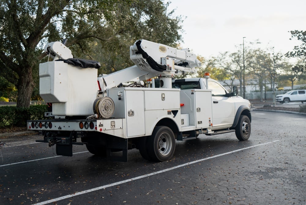 A white commercial bucket truck parked in a lot for commercial auto accidents coverage.